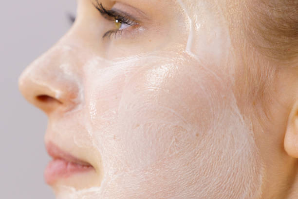 Woman applying facial mask for skincare treatment